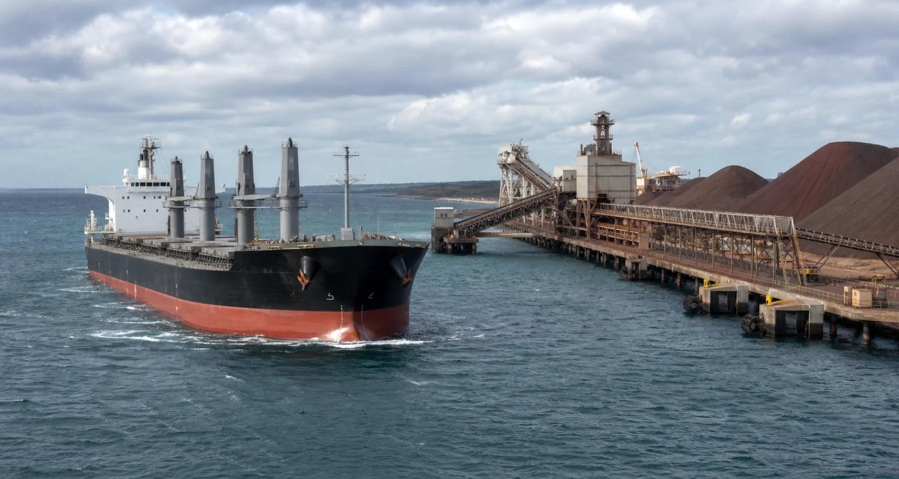 A dry-bulk carrier approaching an industrial mineral terminal.